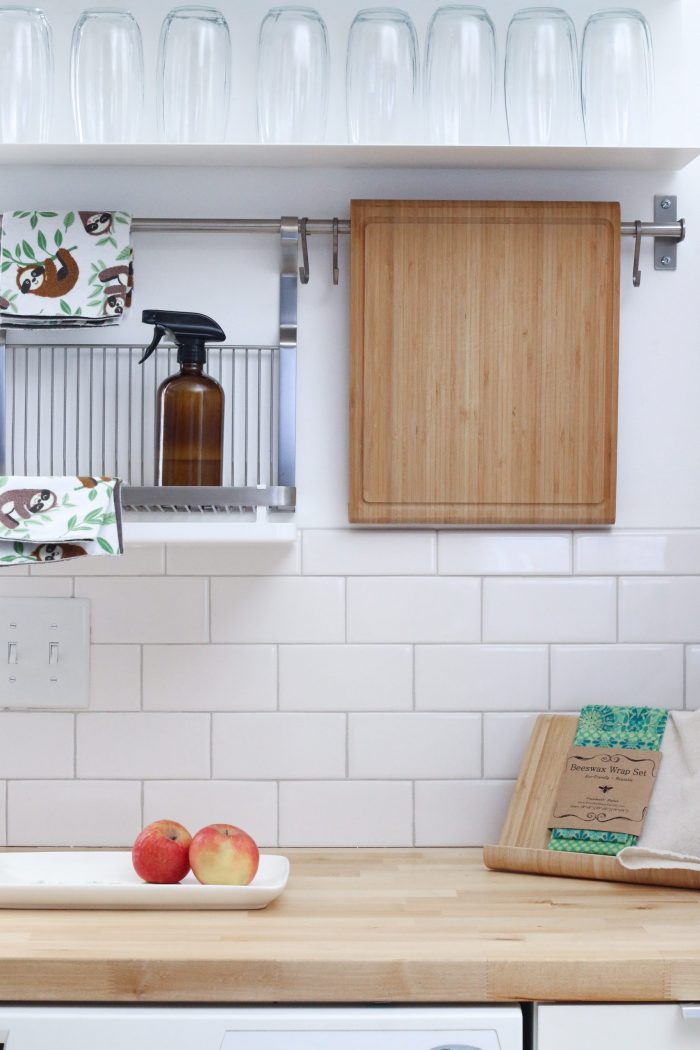 cleaner bottle, apples on a counter, and cutting board in kitchen
