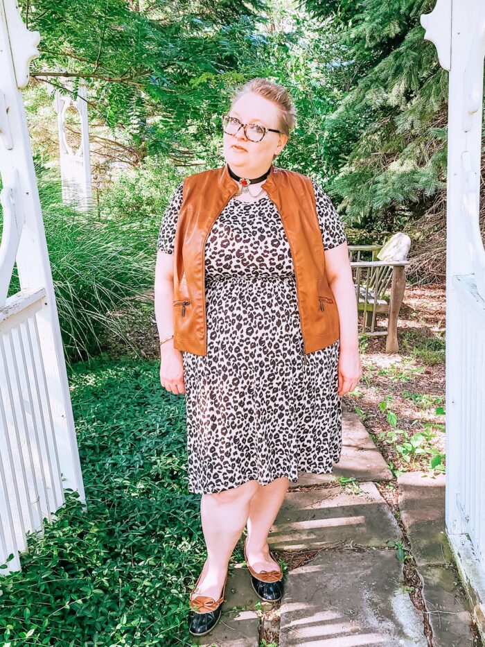 person standing outside wearing leopard print dress and vest