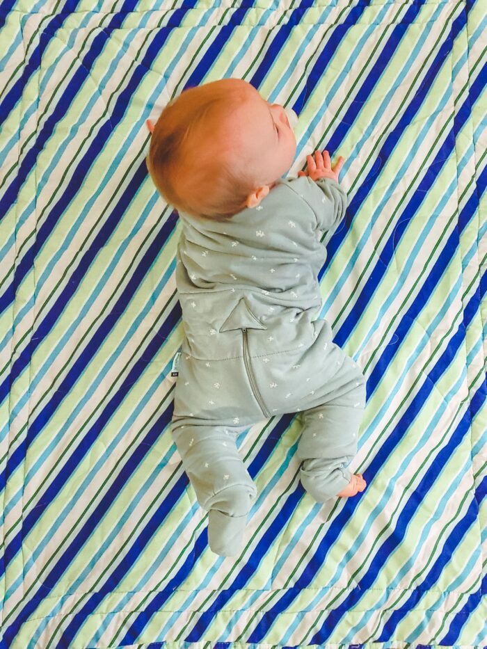 baby in ergoPouch sleep onesie on blanket