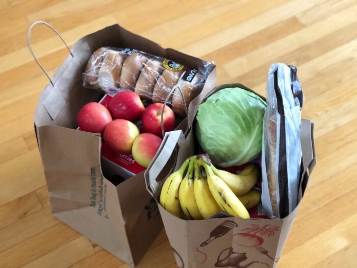Bags of groceries for article about 15 ways you can save money on your grocery bill this month. See how you can cut costs and live more frugally.