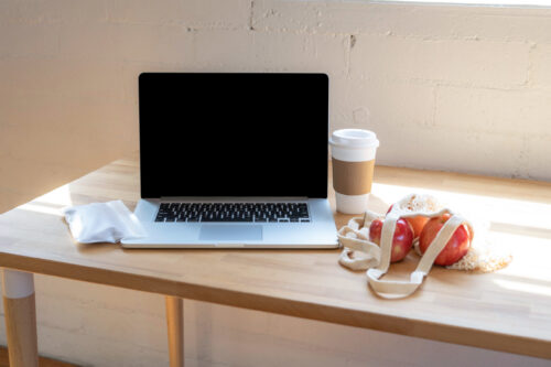 computer, cup, bag of apples