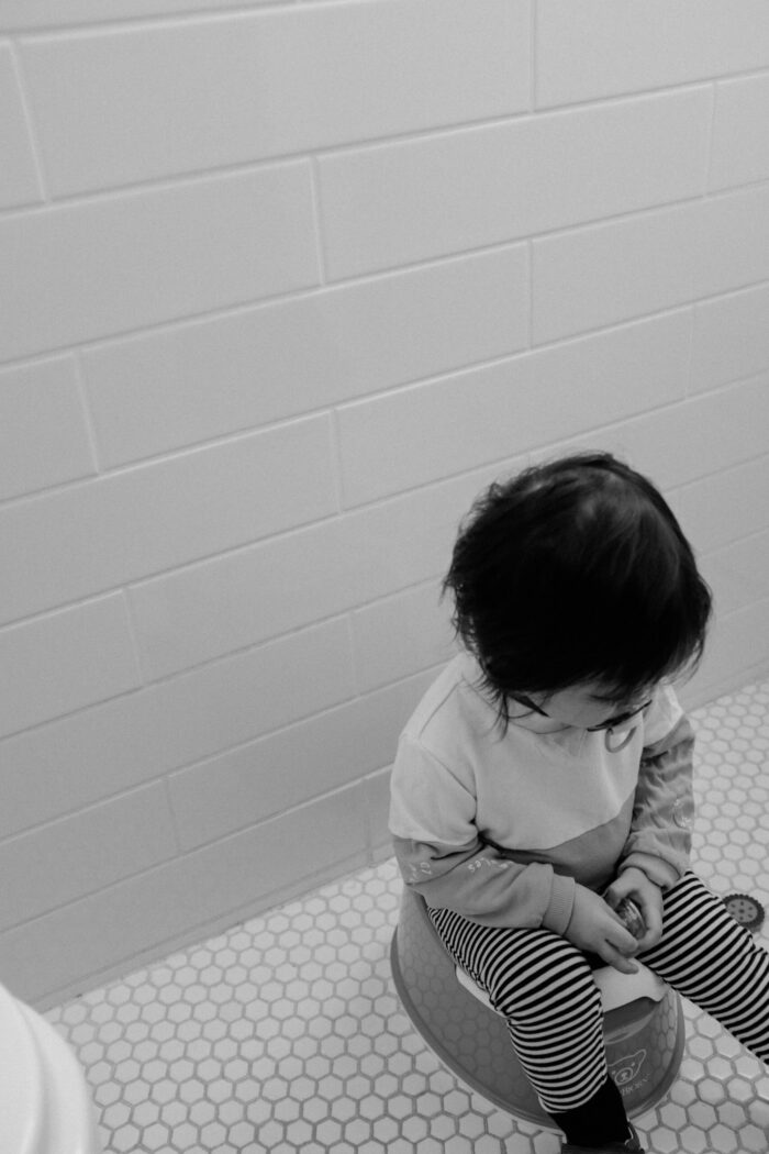 toddler sitting on a potty as a way to help with potty training your toddler