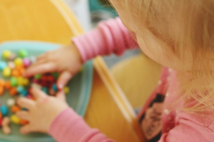 toddler playing with a sensory bin