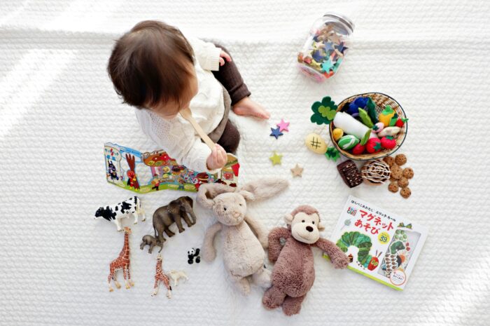 toddler playing with toys on a blanket