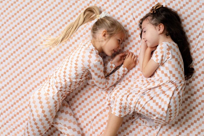 two children dressed in Threee Coastal Babies laying on a blanket